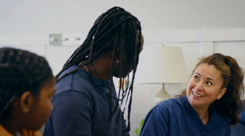 Three individuals talking and smiling.