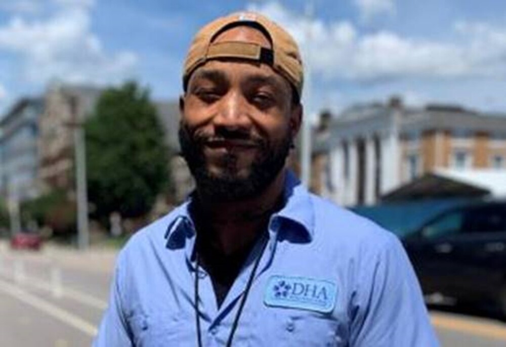 Maintenance Worker Karuan Goldsberry in uniform standing outside near street