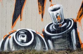 Graffiti on a wall depicting spray paint cans.