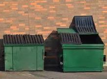 Two green dumpsters. One of them has it's lid open.