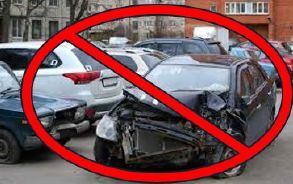 An inoperable car with severe body damage with a red circle and a line going through it over top.