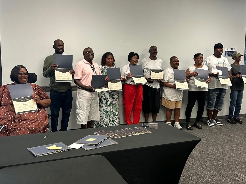 Ten ASCEND Program graduates standing in a line for a group photo with their awards.