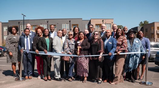 Vanguard resident Bianca Rivera cutting the ceremonial ribbon at Vanguard Apartments.