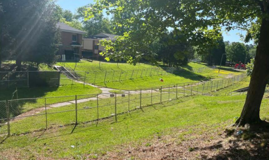 A fenced off area behind several homes.