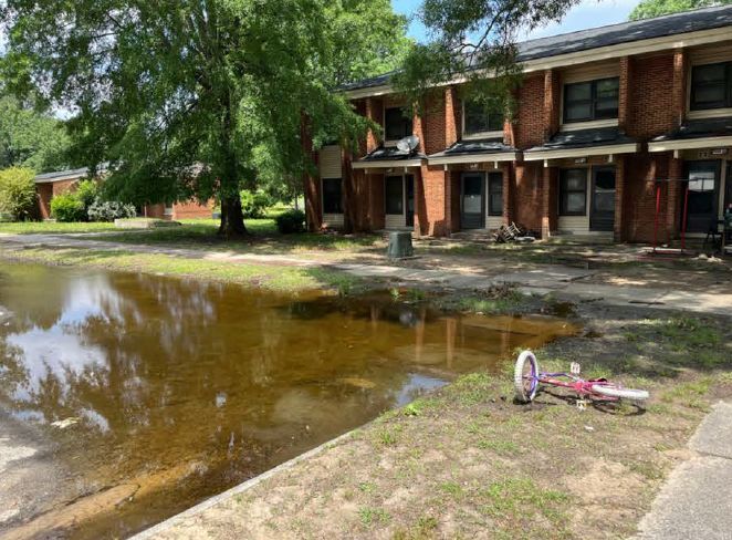 A flooded parking lot in front of a building.