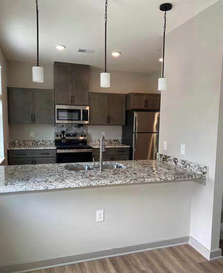 A view of a kitchen with granite counter tops.
