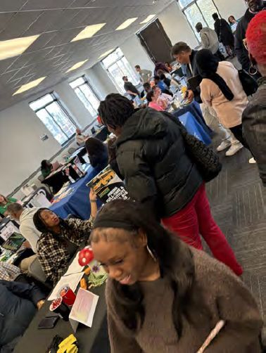 Individuals walking around a job fair to various booths.
