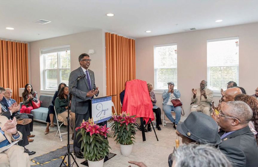 A group of individuals listening to the man speaking at the podium.