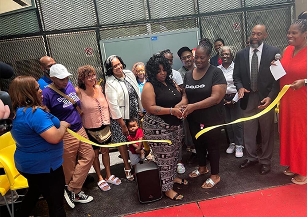 A group of individuals participating in a ribbon cutting.