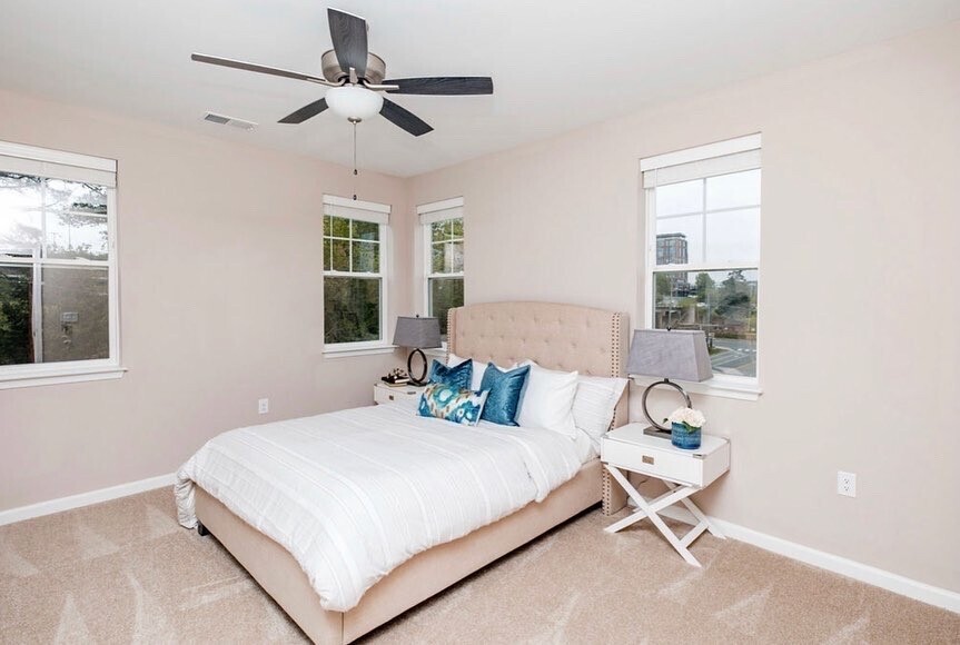 An apartment bedroom with a bed and two bedside tables