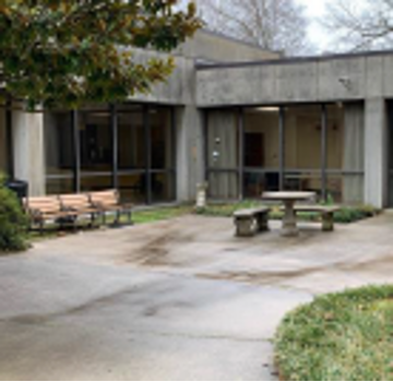 A bench and concrete picnic table in a courtyard.