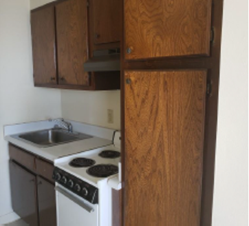 Kitchen cabinets, clean stove and sink.