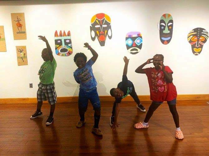 Young artists in front of a display of their work at the Hayti Heritage Center.