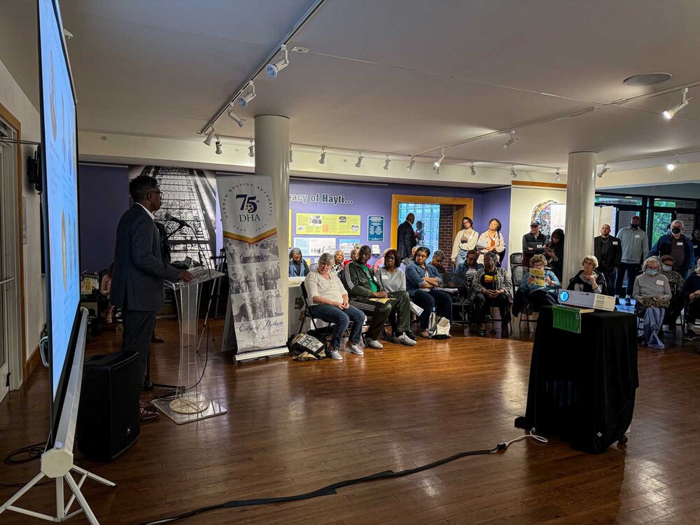 A man in the front of the room, speaking to the audience.