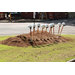 10 shovels with hardhats on shovel handles in pile of dirt