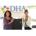 two ladies posing in front of dha sign 