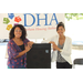 Two ladies posing in front of DHA sign.