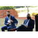 two males in suits sitting down 