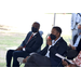 two masked men sitting down listening to speech