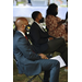 two men in suits and one lady in dress sitting down