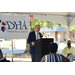 male speaker in front of DHA sign 