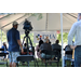 Film camera and back of crowd in tent.