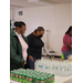 People lined up at a table with beverages 