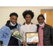 Three men holding an academic award