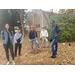 Group of people smiling around a newly planted tree