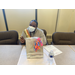 young lady sitting down at a desk with an award and a gift bag