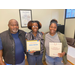 a man and two women standing together holding awards