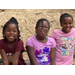 Three girls sitting at a a park