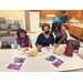 Three women sitting at a table enjoying snacks.