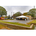 A large white event tent with a park next to it 