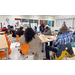 Individuals sitting at desks watching a presentation.