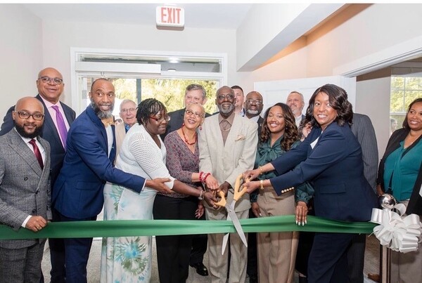 1RibbonCutting.jpg A group of individuals getting ready to cut a green ribbon.