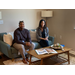 A man and a woman sitting on a couch in a living room.