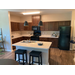 A kitchen with an island in the middle of the room, and appliances.