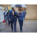 A group of individuals walking under umbrellas.