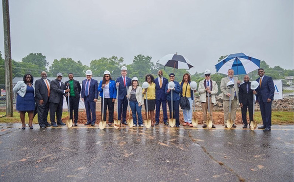 Image4.jpg Various individuals standing outside in the rain with umbrellas.