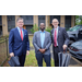 Three men standing together wearing suits.