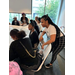 Individuals sitting at large tables working on projects.