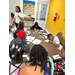 A group of children sitting at a table working on crafts.