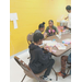 A group of kids sitting at a table working on crafts.