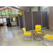 A large room with cubicles that have yellow balloons hanging from them.