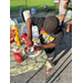 A little boy pouring ketchup on his plate of food.