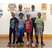 Two adults and four children are posing and smiling for the camera.