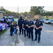 Police smiling while standing next to a little girl.