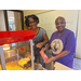 Two women filling a bag of popcorn from the popcorn machine.