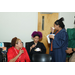 Three women standing close to each other while eating